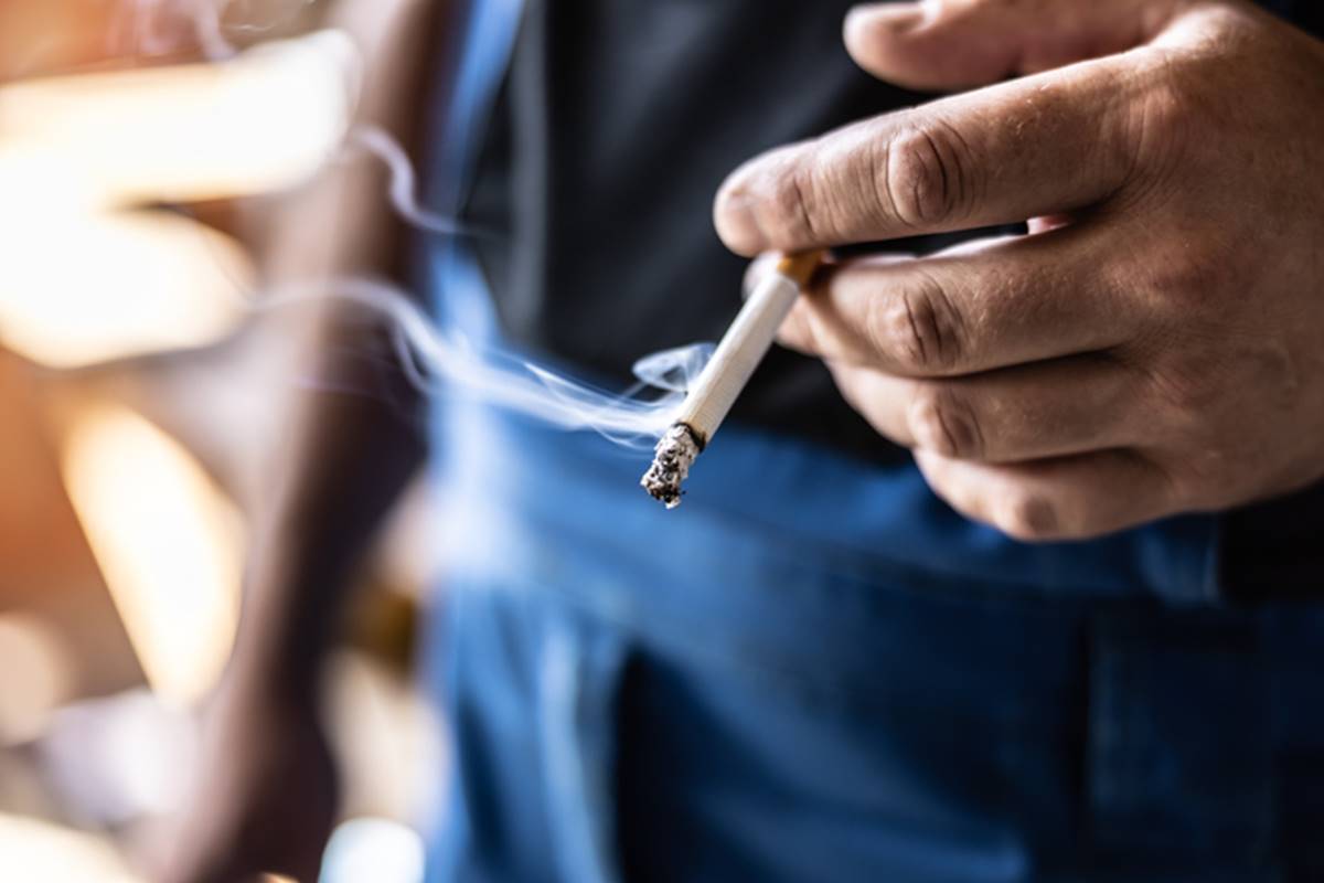 Foto colorida de mão de homem segurando cigarro - Metrópoles - fumar tabagismo