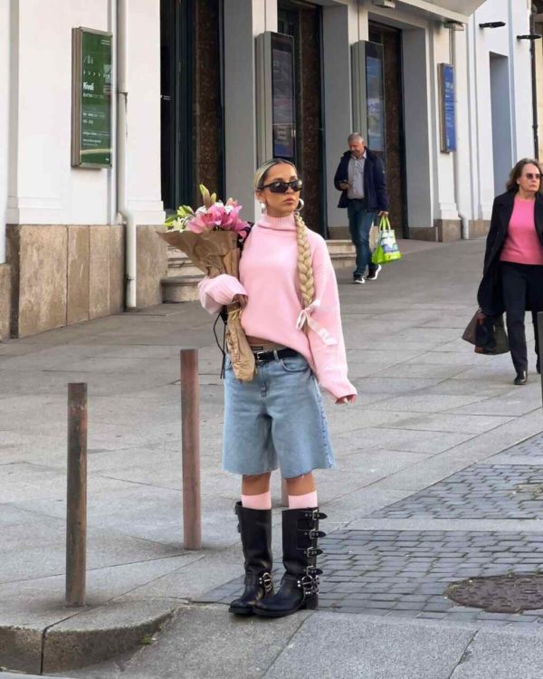 Na imagem com cor, uma mulher branca loira em pé na rua usando um tricot rosa claro - Metrópoles