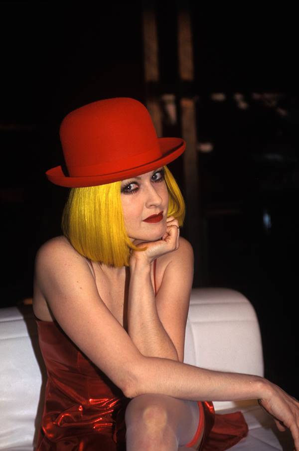 Cyndi Lauper com chapéu vermelho e cabelo amarelo - Metrópoles