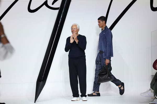 Na passarela, o estilista Giorgio Armani bate palmas enquanto modelo desfila atrás - Metrópoles