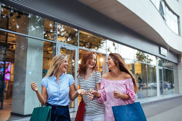 Três jovens mulheres carregando sacolas de compras - Metrópoles