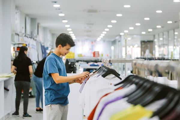 Adolescente escolhendo roupas para comprar - Metrópoles