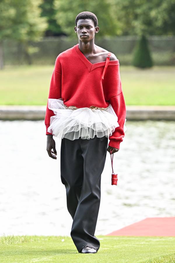 Em desfile no Grande Canal do Palácio de Versalhes, modelo usa suéter vermelho com renda na cintura e calça preta - Metrópoles