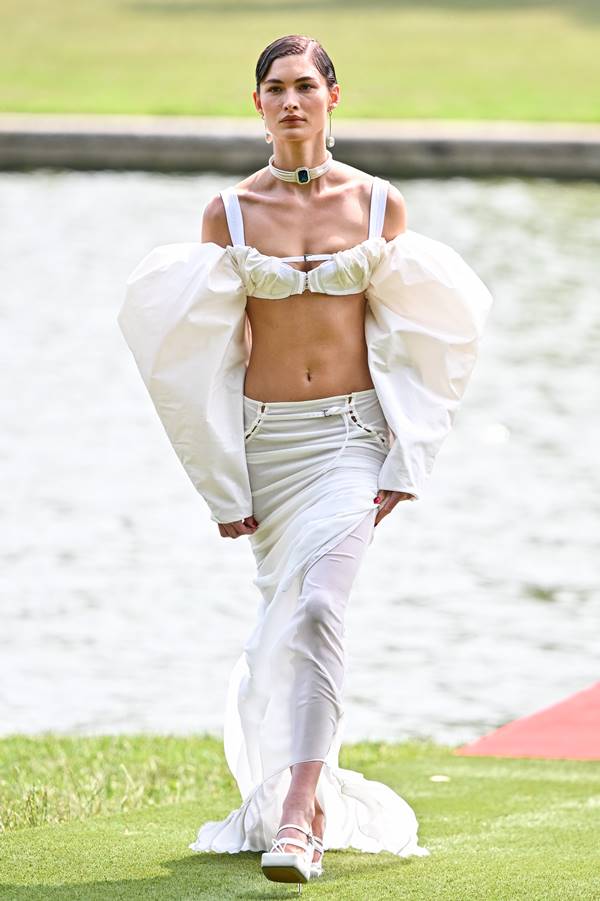 Em desfile no Grande Canal do Palácio de Versalhes, modelo usa look branco com saia longa e top de mangas bufantes - Metrópoles