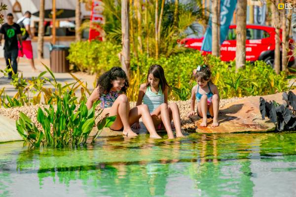 Fotografia colorida mostrando crianças brincando em lagoa artificial-Metrópoles