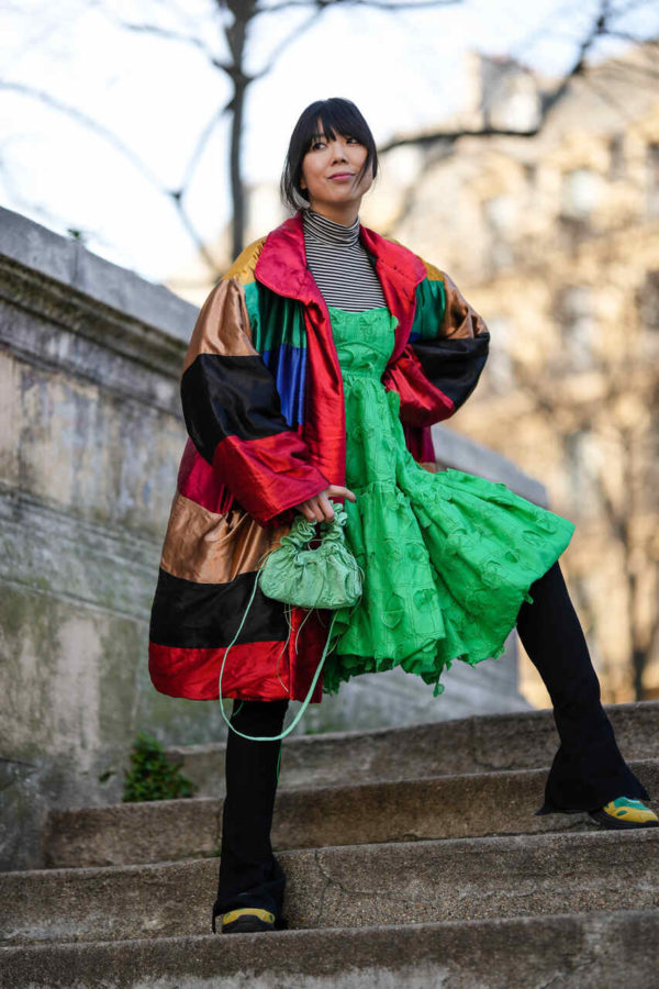 Na imagem com cor, uma mulher asiática andando na rua - Metrópoles