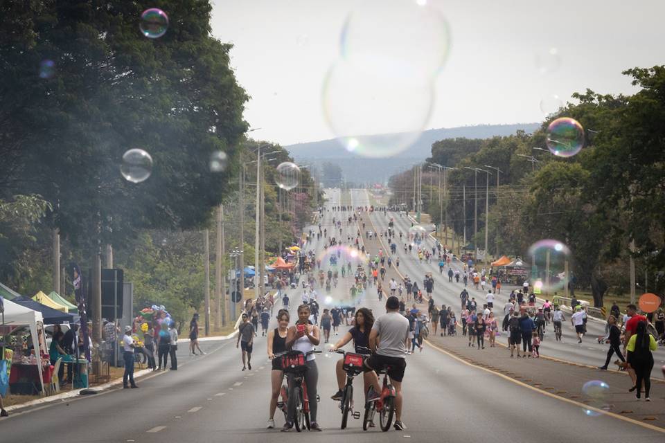 pessoas andando na rua e bolhas de sabão em primeiro plano - metrópoles