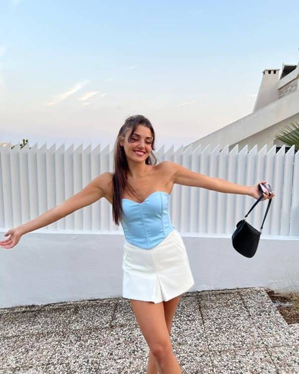 Atriz turca Hande Erçel usando blusa azul sem alças e saia branca - Metrópoles