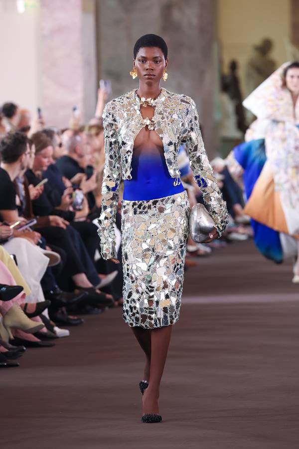 Na passarela da Schiaparelli, modelo usa look com pedaços de vidro bordados. Na barriga, tinta azul - Metrópoles