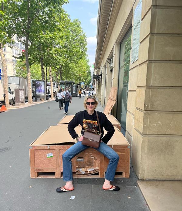 Mulher sentada em caixote de madeira posicionado na rua - Metrópoles