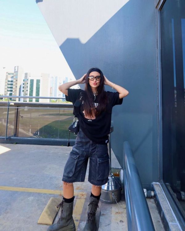 Na imagem com cor, uma mulher branca em pé usando camiseta calça capri - Metrópoles