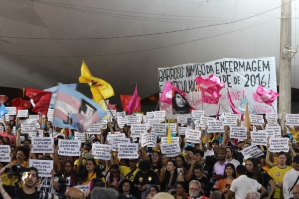 Grupo segura placas em apoio ao piso da enfermagem