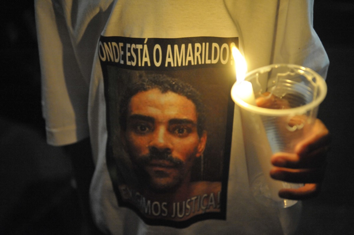 Pessoa usando camiseta com imagem de Amarildo em um protesto