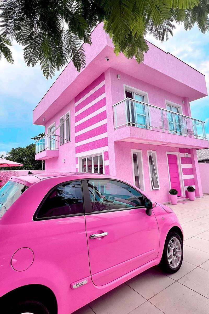 Foto colorida de casa com um andar superior e um carro, ambos cor-de-rosa - Metrópoles 