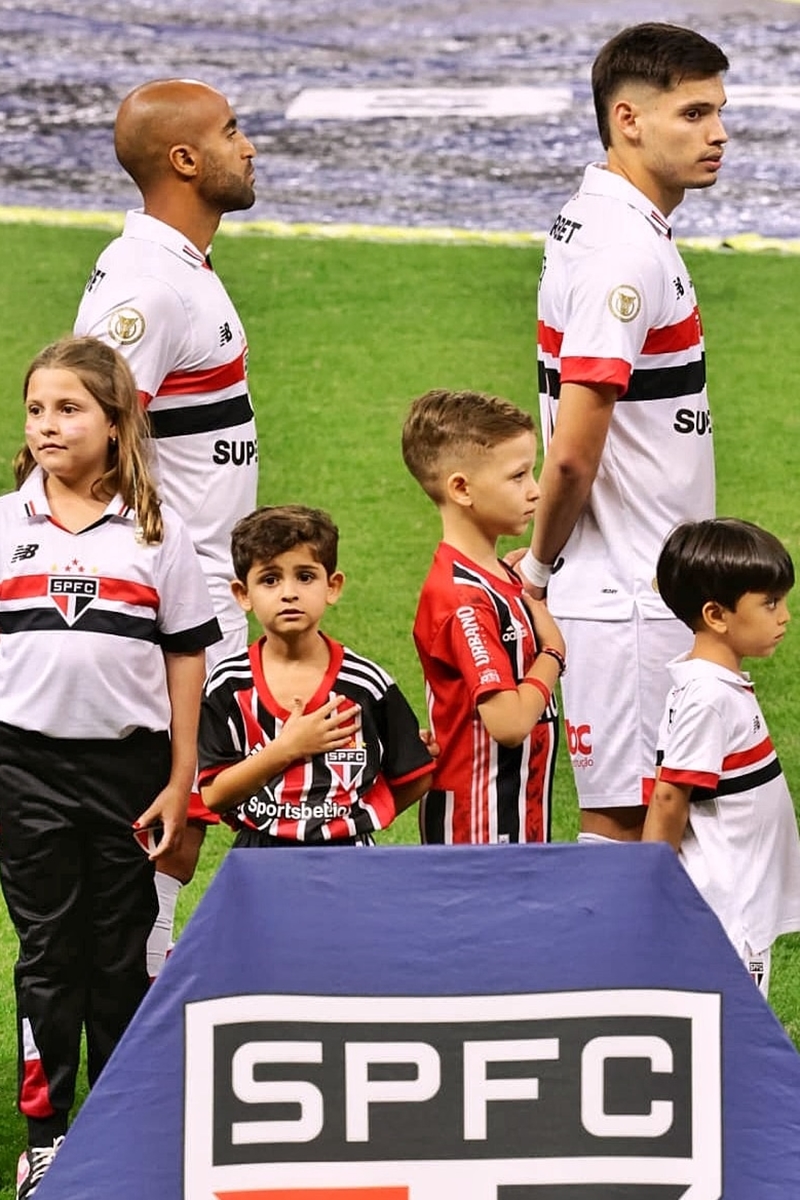 Foto colorida - Jogadores do São Paulo com as crianças