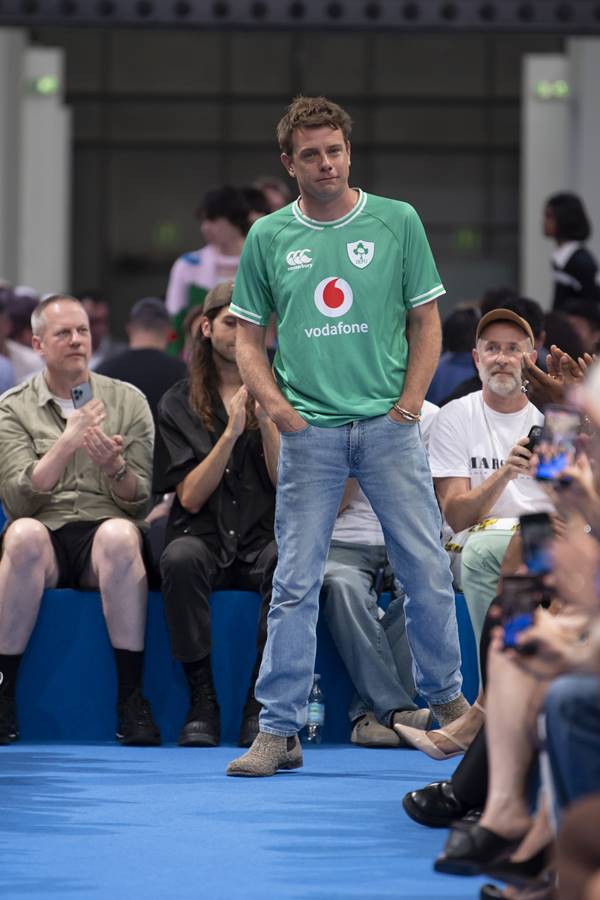 Na passarela de moda, usando blusa verde e calça jeans, o estilista Jonathan Anderson - Metrópoles