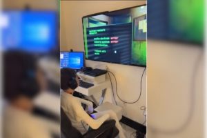 Imagem colorida de jovem sentado em cadeira em frnete a talveisão jogando video game - Metrópoles