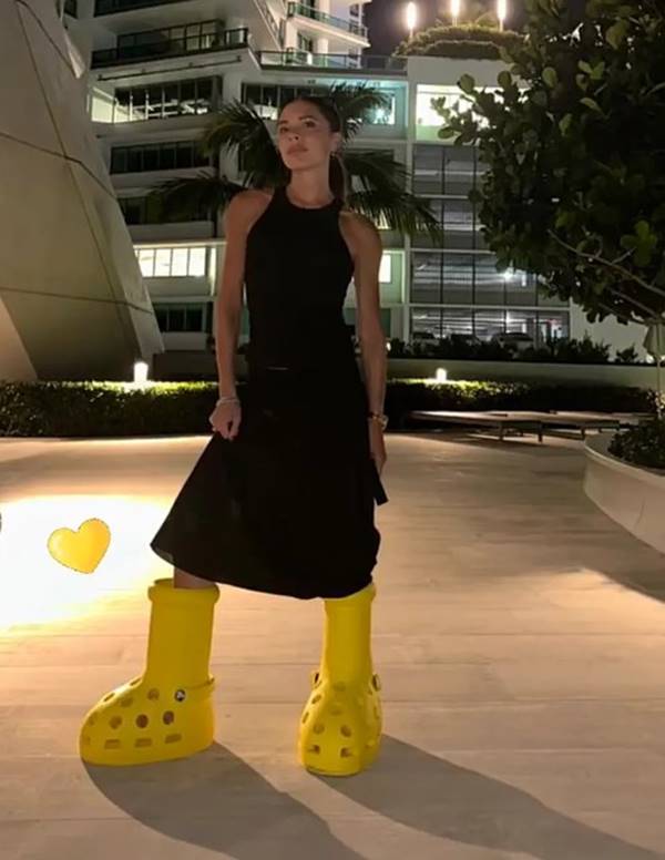 Victoria Beckham usa vestido preto e bota amarela gigante - Metrópoles