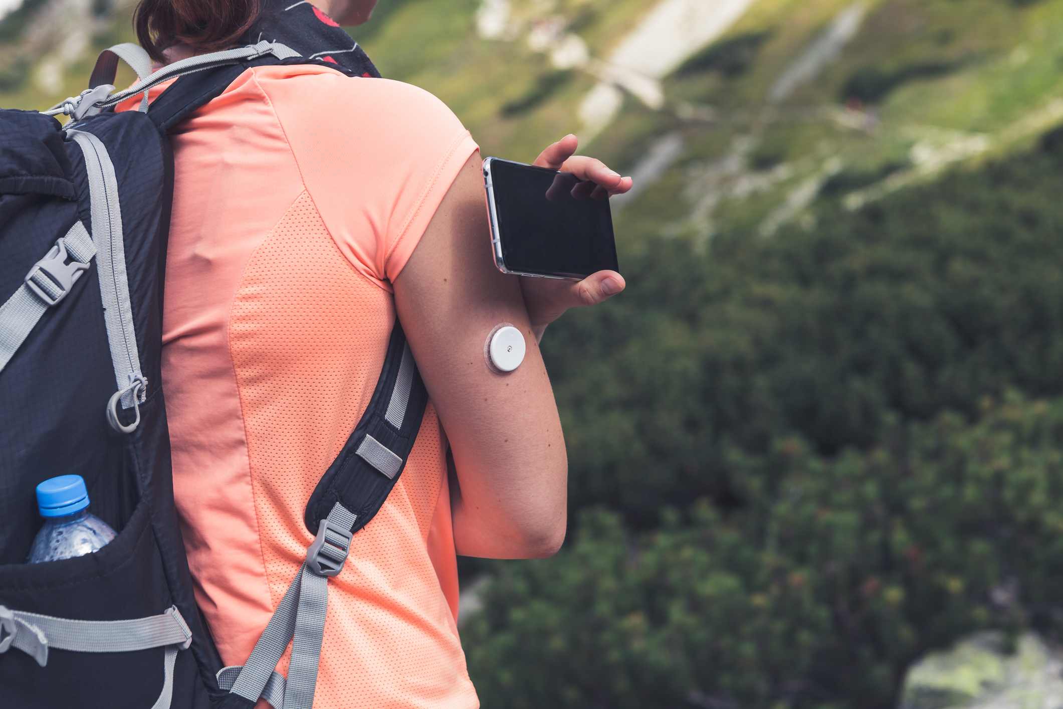 Foto mostra pessoa com monitor de insulina de diabetes tipo 2 caminhando ao ar livre - Metrópoles