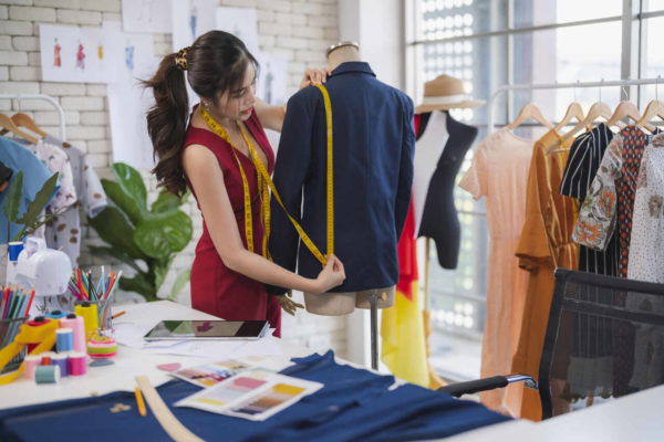 Na aimagem com cor, uma mulher branca costurando roupas - Metrópoles