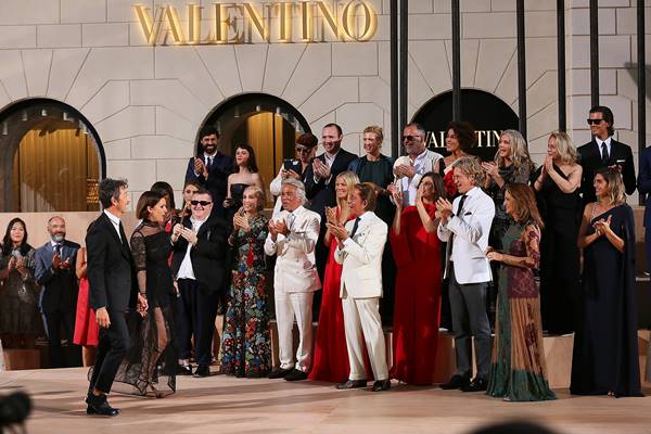 Grupo de pessoas celebrando em desfile da Valentino - Metrópoles