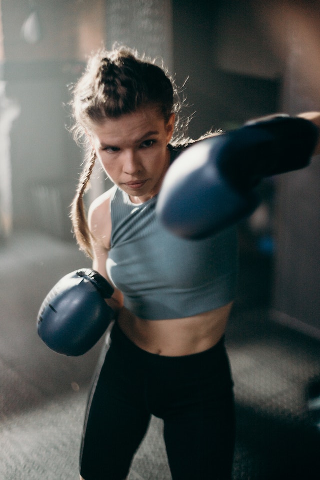 Jovem mulher com luvas de boxe lutando - Metrópoles