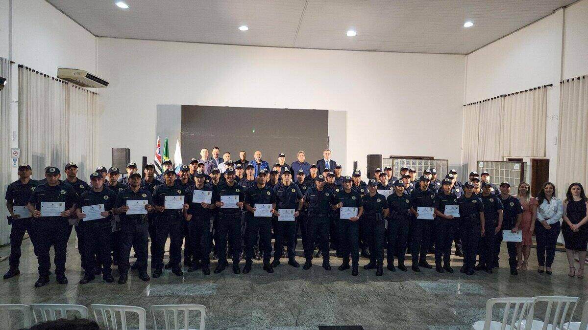 Em foto colorida 57 guardas civis municipais seguram diploma de formação - Metrópoles