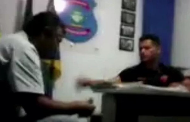 Imagem colorida do delegado Rilmo Braga entregando dinheiro dentro de delegacia em Morrinhos em 2015 - Metrópoles