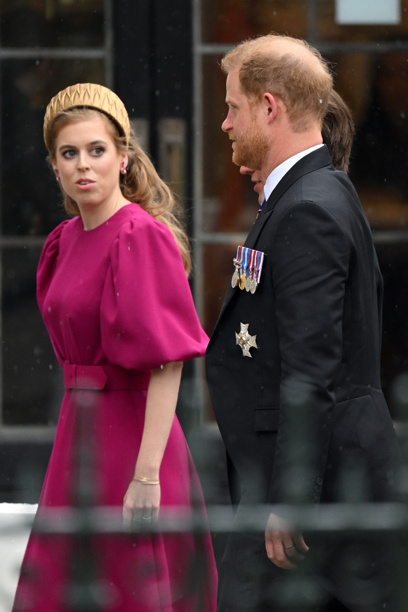 Foto colorida. Mulher loira e branca usa vestido rosa. Al seu lado está o primo, um homem branco, ruivo, de terno preto