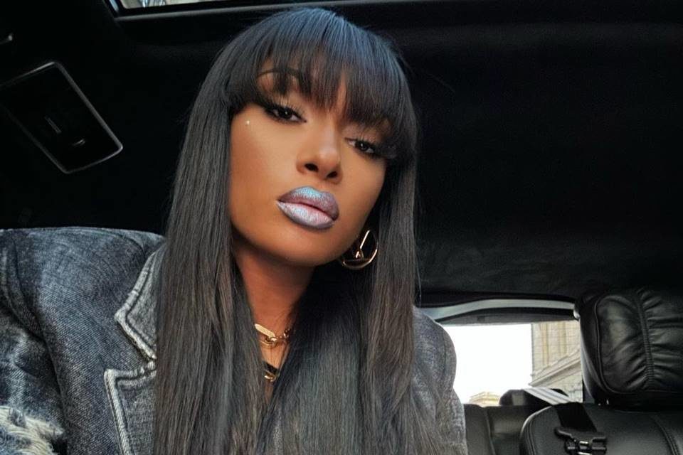 Foto colorida de Megan Thee Stallion usando batom cinza e com franja - Metrópoles