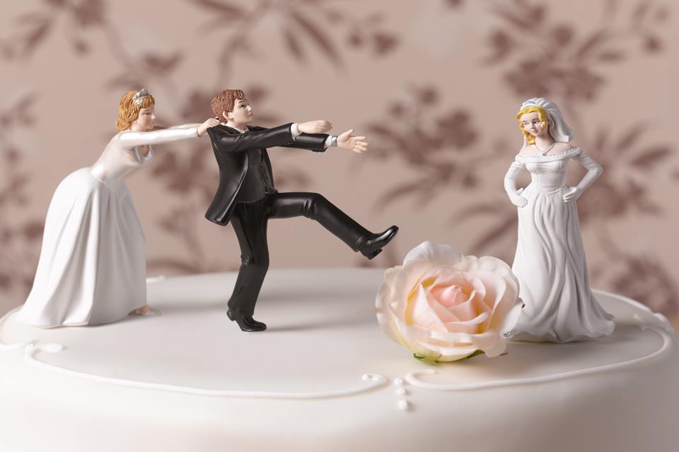Na foto, um bolo de casamento decorado com três bonecos - Metrópoles