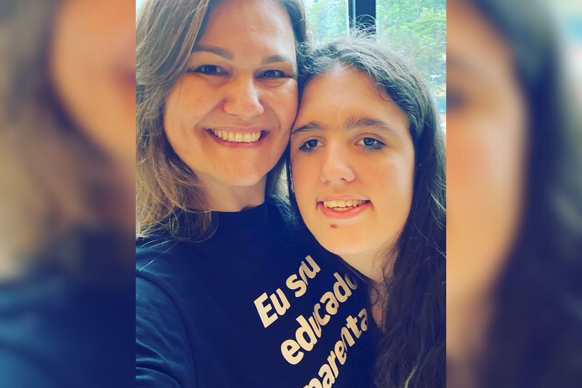 Imagem colorida de mãe e filha abaraçadas sorrindo para a foto - Metrópoles