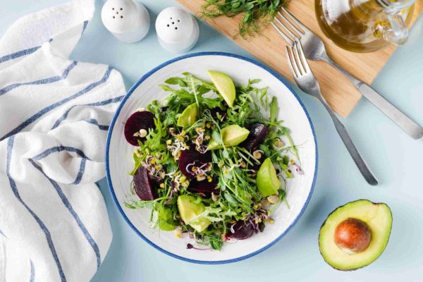 Prato de salada com beterraba, abacate e rúcula