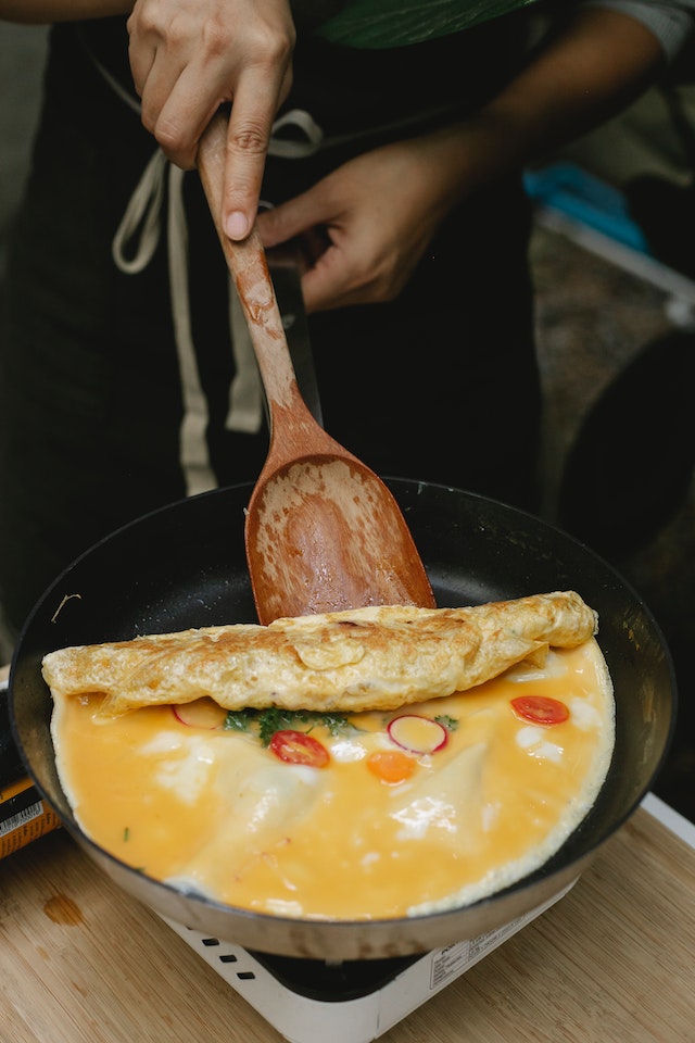 Homem cozinhando omelete com colher de pau - Metrópoles
