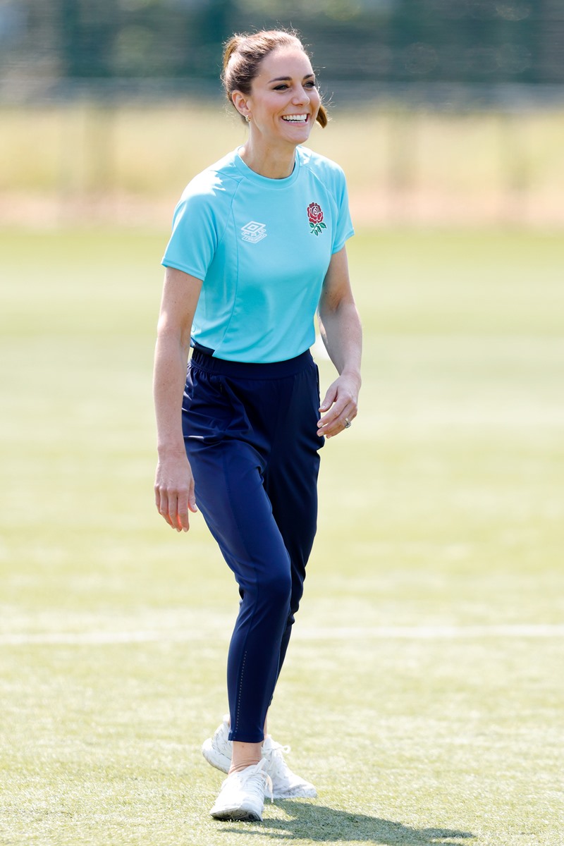 Foto colorida de mulher branca, com cabelo amarrado. Ela está em pé e usa uma calça azul escuro e uma blusa azul claro - Metrópoles