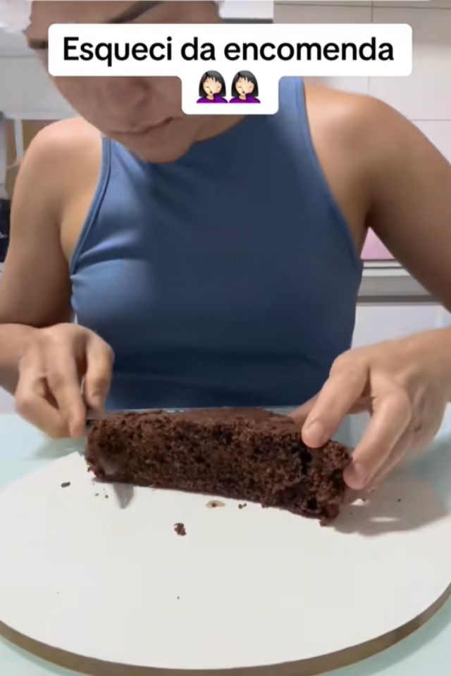 Foto colorida de uma mulher decorando um bolo de chocolate - Metrópoles