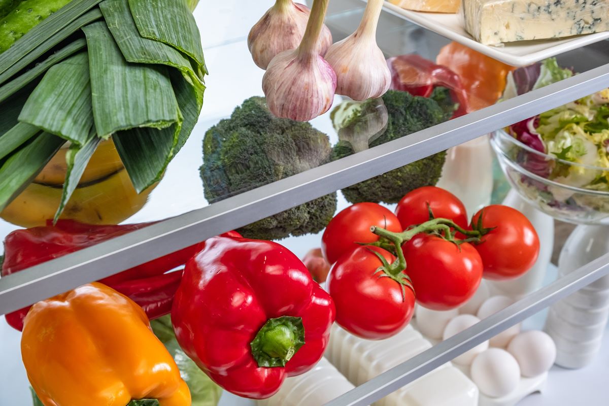 Foto colorida de alimentos em prateleiras de geladeira - Metrópoles