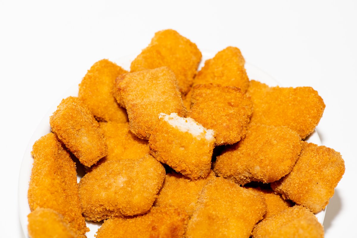 Foto colorida de nuggets de frango empilhados - Metrópoles