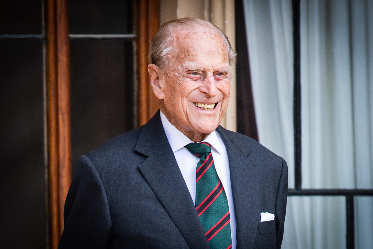 Foto colorida. Imagem mostra o falecido principe philip vestindo um terno preto e sorrindo - Metrópoles