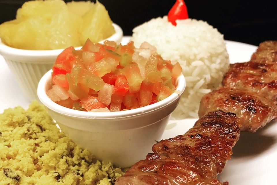 Foto de um prato de comida com arroz, mandioca e carne - Metrópoles