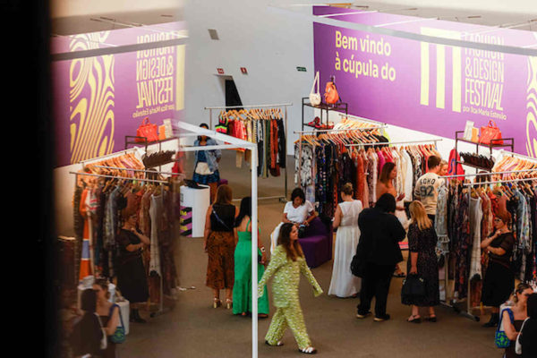 Na imagem com cor, pessoas olhando roupas no MFDF - Metrópoles