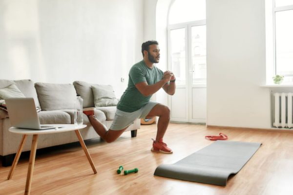 pessoa treinando em casa exercícios físicos