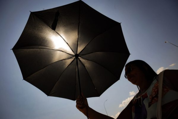 Pessoa se proteje do calor recorde em Brasília Df que chega a 34,6 - Metrópoles