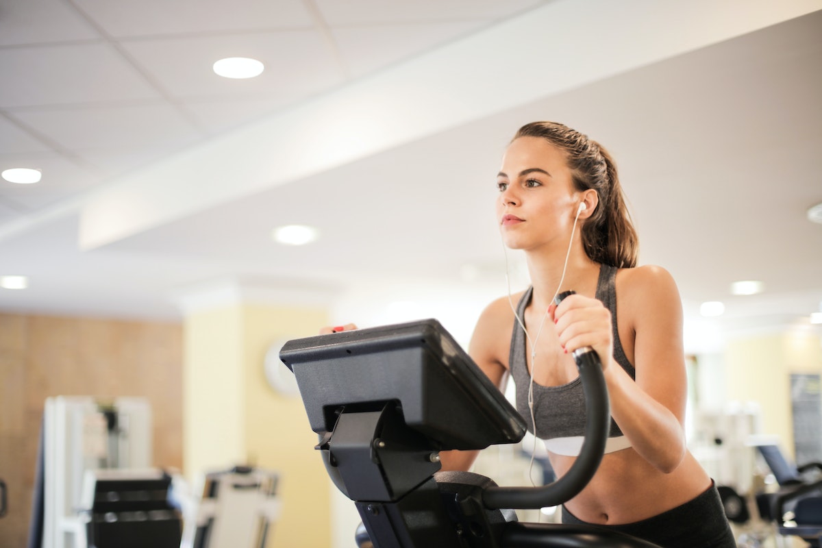 Jovem mulher realizando exercício físico em academia - Metrópoles