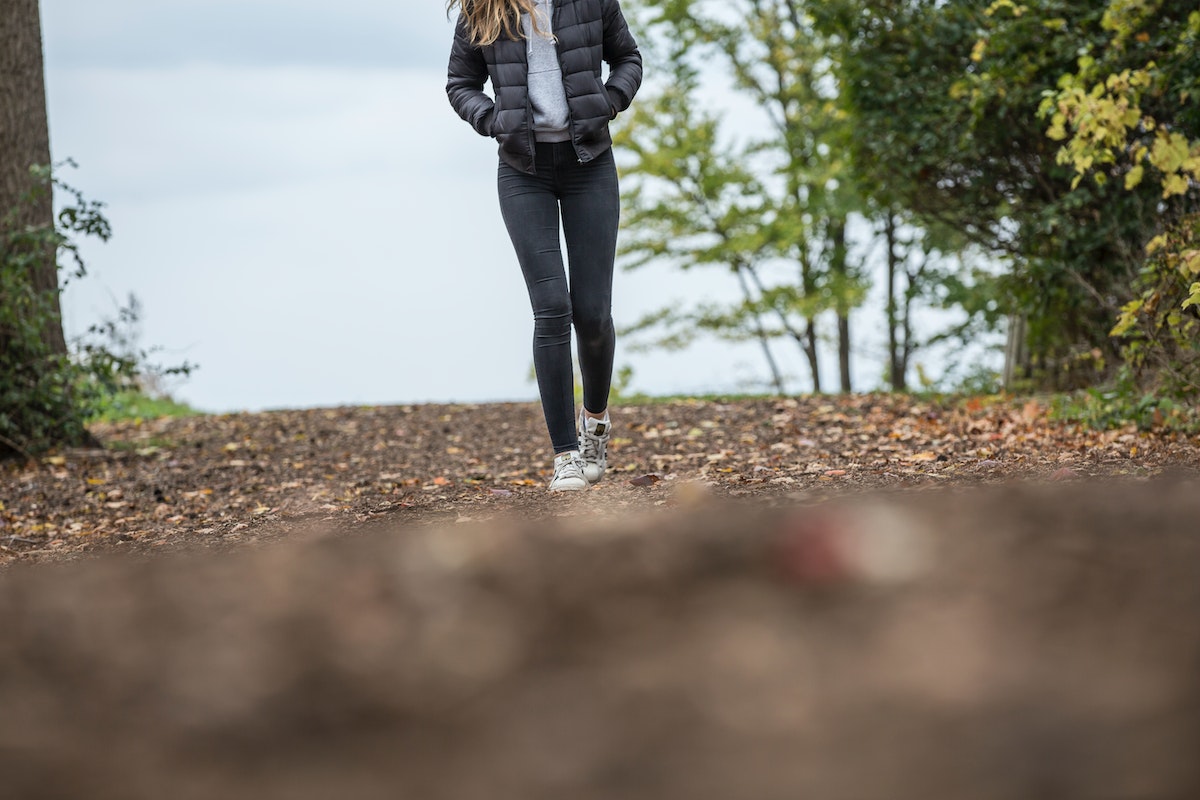 Jovem mulher caminhando ao ar livre - Metrópoles