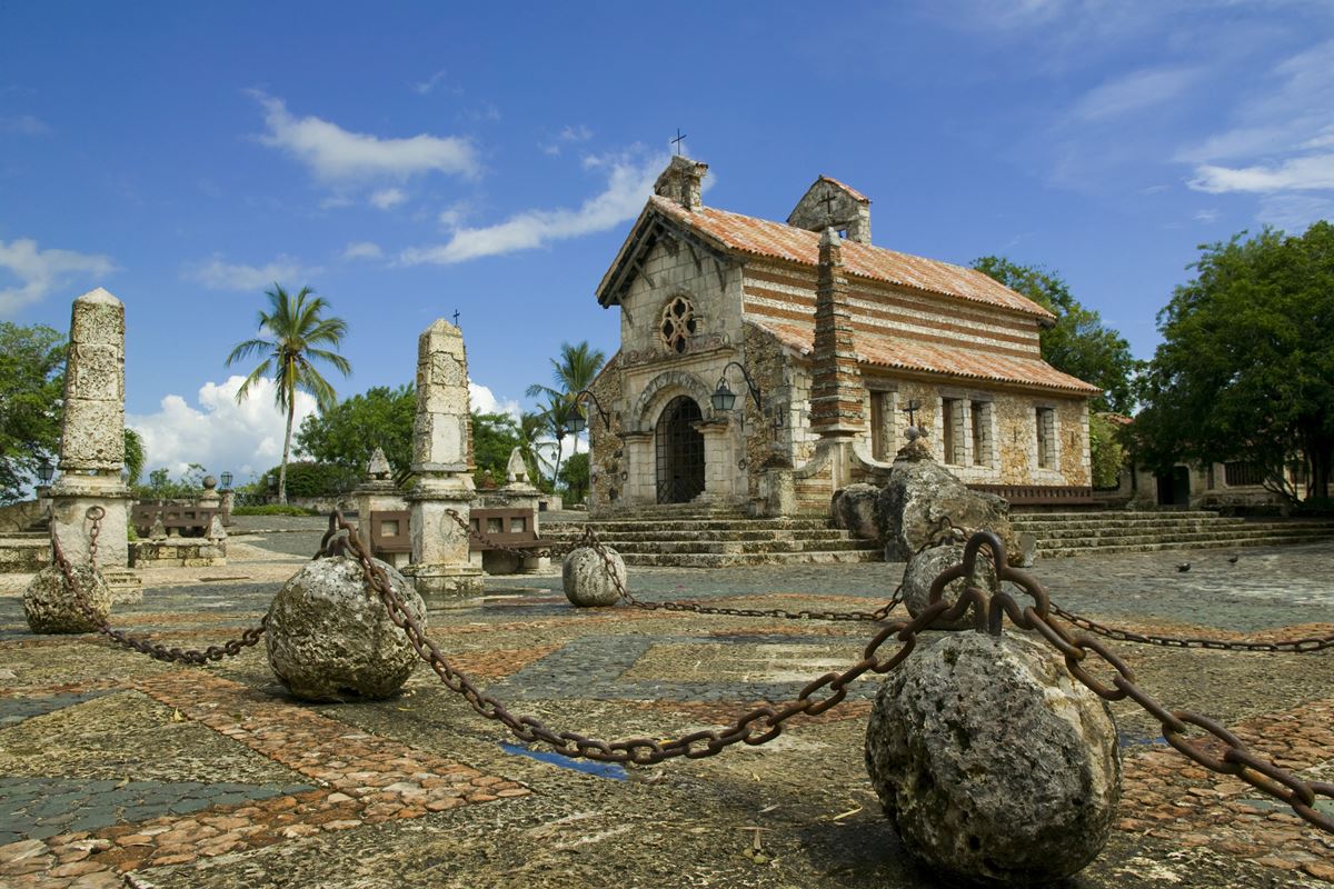 Foto colorida de igreja antiga, com pedras em volta e detalhes rochosos - Metrópoles