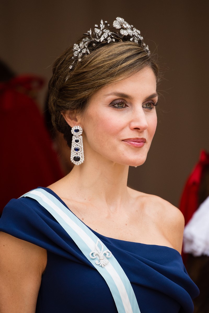 Foto colorida de tronco de mulher parda, maquiada e com tiara na cabeça. Ela usa uma roupa azul escuro com uma faixa em cor mais clara - Metrópoles