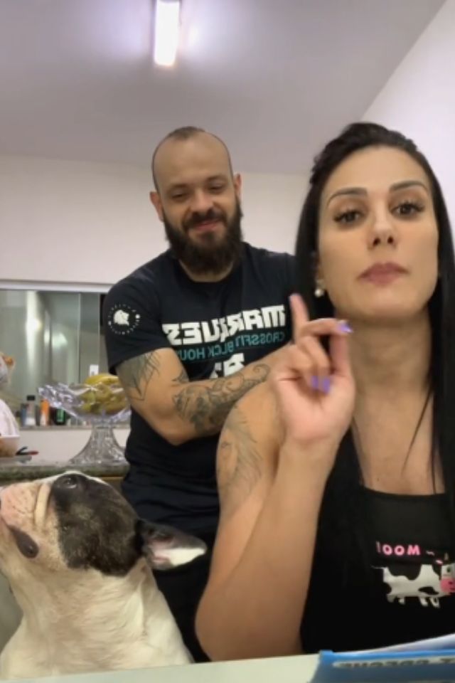 Foto colorida de uma mulher e um homem ao lado de um cachorro - Metrópoles