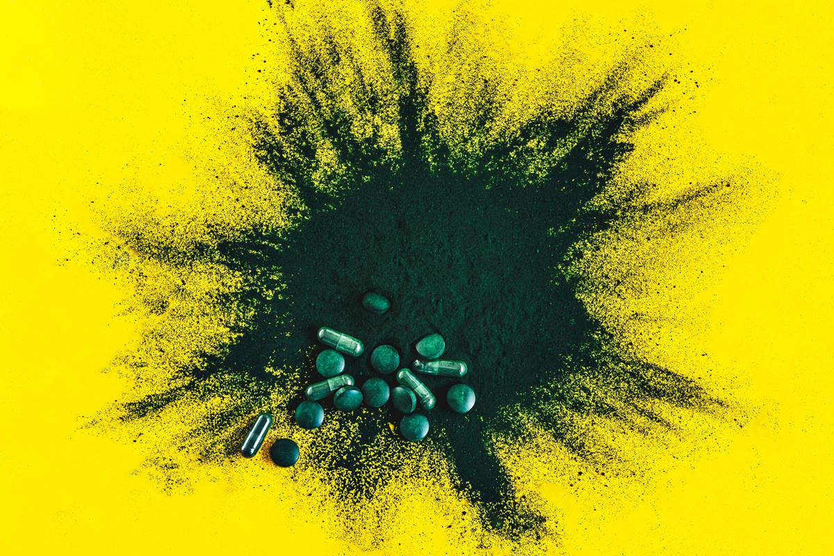Foto colorida de pó e comprimidos na cor verde - Metrópoles