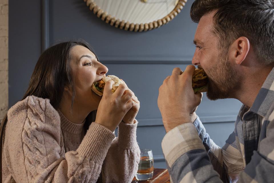 Foto colorida de um casal comendo - Metrópoles